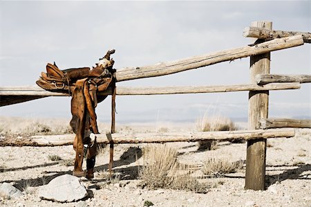 ranch nobody usa - ranch scene - saddle on rural fence, vintage worn saddle in the dry and barren countryside Stock Photo - Budget Royalty-Free & Subscription, Code: 400-04062888