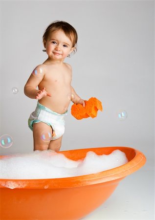 Lovely kid with orange sponge ready to take bath Stock Photo - Budget Royalty-Free & Subscription, Code: 400-04094489