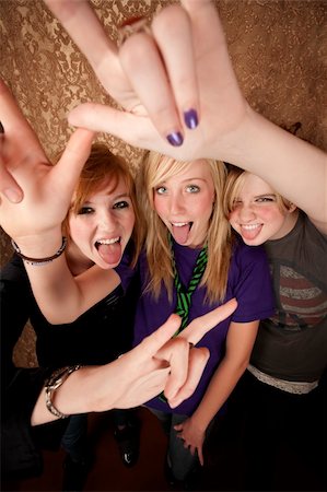 Portrait of three pretty young girls on a gold background making bull horn gestures Stock Photo - Budget Royalty-Free & Subscription, Code: 400-04095425