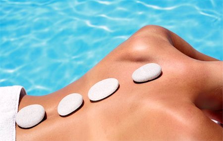 simsearch:400-05318677,k - Woman with massage stones by a blue pool Stock Photo - Budget Royalty-Free & Subscription, Code: 400-04117808
