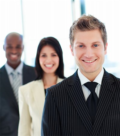 Smiling businessman in front of his team in office Stock Photo - Budget Royalty-Free & Subscription, Code: 400-04118180