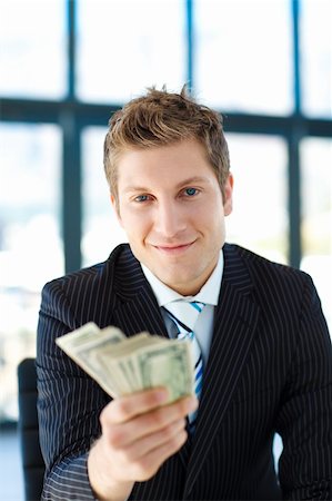 simsearch:400-05718324,k - Handsome junior businessman holding dollars and looking to the camera Stock Photo - Budget Royalty-Free & Subscription, Code: 400-04118204