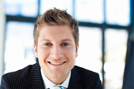 simsearch:400-05715208,k - Attractive young businessman smiling at the camera in office Stock Photo - Budget Royalty-Free & Subscription, Code: 400-04118208