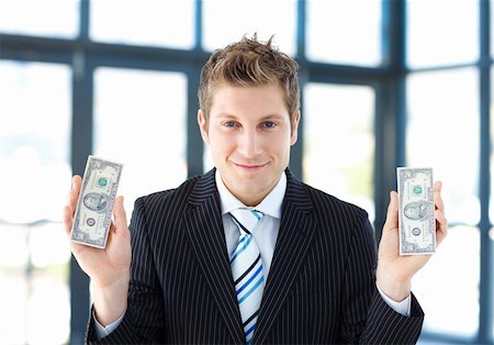 simsearch:400-05718324,k - Attractive businessman holding dollars in office Stock Photo - Budget Royalty-Free & Subscription, Code: 400-04118209