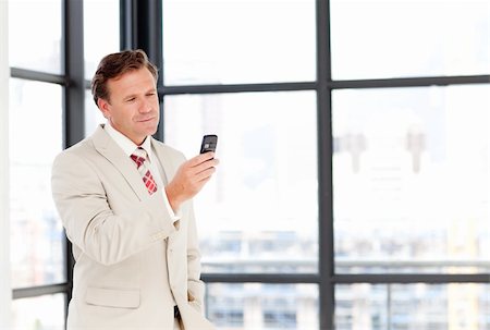 phone one person adult smile elderly - Senior businessman texting on his mobile phone with copy-space Stock Photo - Budget Royalty-Free & Subscription, Code: 400-04118257
