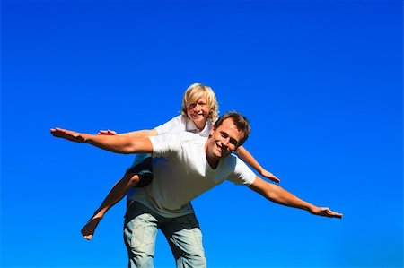 Young boy on father's back playing airplane outdoors Stock Photo - Budget Royalty-Free & Subscription, Code: 400-04118328