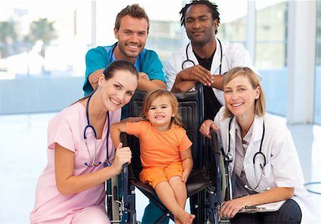 doctor consulting patient in hospital room - Group of doctors with a little girl in a wheelchair smiling at the camera Stock Photo - Budget Royalty-Free & Subscription, Code: 400-04118495