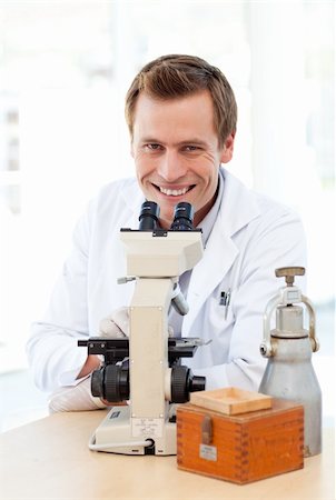 simsearch:400-05669968,k - Smiling scientist looking through a microscope in a laboratory Stock Photo - Budget Royalty-Free & Subscription, Code: 400-04118507