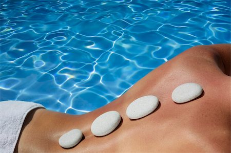 simsearch:400-05318677,k - Woman with volcanic massage stones in front of a blue spa pool Stock Photo - Budget Royalty-Free & Subscription, Code: 400-04119603