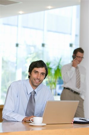 simsearch:400-04113367,k - Confident smiling young business man working on laptop Stock Photo - Budget Royalty-Free & Subscription, Code: 400-04111334