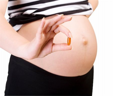simsearch:400-04396054,k - belly of pregnant woman with capsules in hand isolated with clipping path on white Stock Photo - Budget Royalty-Free & Subscription, Code: 400-04126147