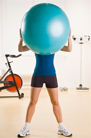 simsearch:400-04128723,k - Femme tenant un ballon d'exercice au club de santé Photographie de stock - Aubaine LD & Abonnement, Code: 400-04128731