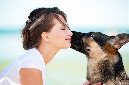 dog licking woman - Dog is licking a face of a young beautiful woman Stock Photo - Budget Royalty-Free & Subscription, Code: 400-04120470