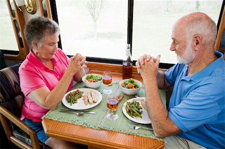 Senior couple say grace before eating a meal in their motor home. Stock Photo - Budget Royalty-Free & Subscription, Code: 400-04131220