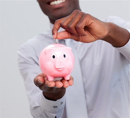 simsearch:400-05715208,k - Afro-American businessman saving money in a piggybank in the office Stock Photo - Budget Royalty-Free & Subscription, Code: 400-04156512