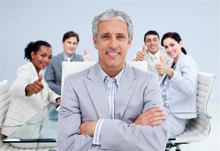 Happy businessman leading his happy team with thumbs up in the office Photographie de stock - Aubaine LD & Abonnement, Code: 400-04156656