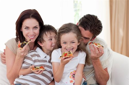 simsearch:400-04193348,k - Smiling family eating pizza in the living-room Stock Photo - Budget Royalty-Free & Subscription, Code: 400-04157559