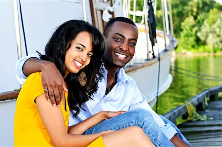 Young romantic couple sitting on dock in front of yacht Stock Photo - Budget Royalty-Free & Subscription, Code: 400-04158548
