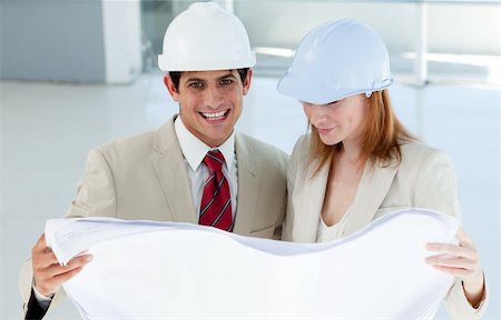 Two smiling engineers studying blueprints in a building site Stock Photo - Budget Royalty-Free & Subscription, Code: 400-04159656