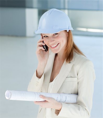 Smiling female architect with hardhat on phone in a building site Stock Photo - Budget Royalty-Free & Subscription, Code: 400-04159659