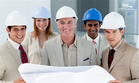 Architects with hardhats in a building site smiling at the camera Stock Photo - Budget Royalty-Free & Subscription, Code: 400-04159653