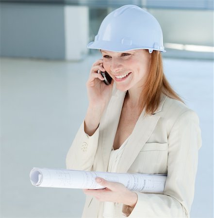 Young female engineer on phone carrying blueprints Stock Photo - Budget Royalty-Free & Subscription, Code: 400-04159660