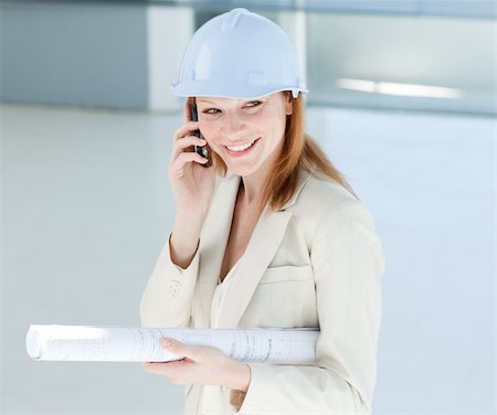 Attractive engineer on phone smiling at the camera Stock Photo - Budget Royalty-Free & Subscription, Code: 400-04159661