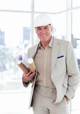 Senior architect with a hardhat holding blueprints in a building site Stock Photo - Budget Royalty-Free & Subscription, Code: 400-04159721