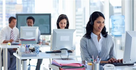 Ethnic businesswoman with a headset on in a call center with her colleagues Stock Photo - Budget Royalty-Free & Subscription, Code: 400-04150246