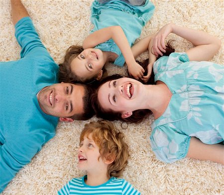 simsearch:400-04654755,k - Smiling family lying on floor in a circle with heads together Foto de stock - Super Valor sin royalties y Suscripción, Código: 400-04151194