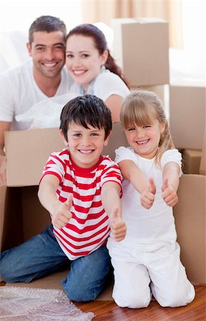 Happy family moving house with boxes around and thumbs up Stock Photo - Budget Royalty-Free & Subscription, Code: 400-04151960