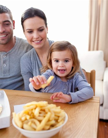 simsearch:400-04193348,k - Little girl eating fries at home with her parents Stock Photo - Budget Royalty-Free & Subscription, Code: 400-04152146