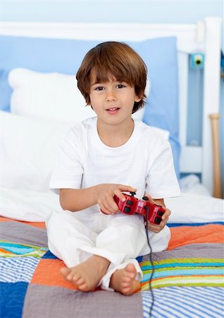 simsearch:400-05751526,k - Little boy sitting in bed playing videogames Stock Photo - Budget Royalty-Free & Subscription, Code: 400-04152191