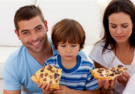 simsearch:400-04193348,k - Happy parents and boy eating pizza in living-room all together Stock Photo - Budget Royalty-Free & Subscription, Code: 400-04152230