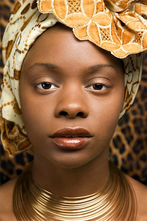 Close-up portrait of an African American woman wearing traditional African clothing in front of a patterned wall. Vertical format. Stock Photo - Budget Royalty-Free & Subscription, Code: 400-04164721