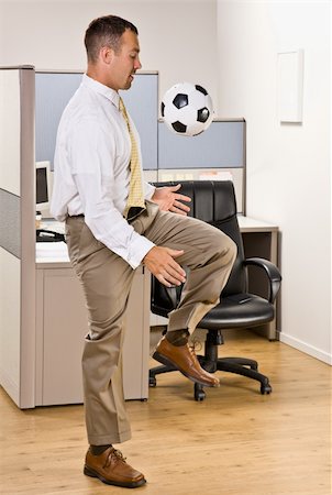 Businessman playing with soccer ball in office Stock Photo - Budget Royalty-Free & Subscription, Code: 400-04168501