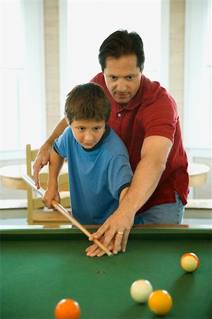 pool child - Man shooting game of pool with young boy.  Vertically framed shot. Foto de stock - Super Valor sin royalties y Suscripción, Código: 400-04162289