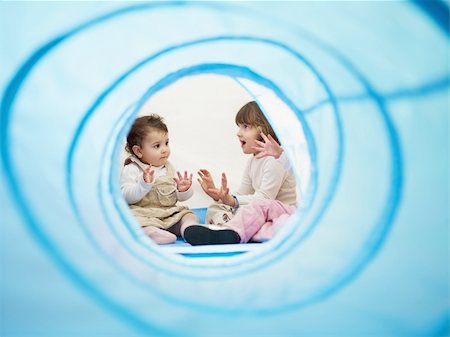 female toddler and 2-3 years old girls viewed from blue toy tunnel, clapping hands and singing. Horizontal shape, Copy space Foto de stock - Super Valor sin royalties y Suscripción, Código: 400-04175089