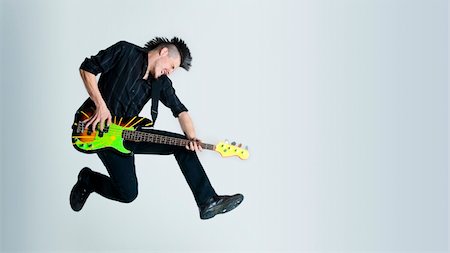 Awesome mohawk man jumps with his guitar in studio Stock Photo - Budget Royalty-Free & Subscription, Code: 400-04175906