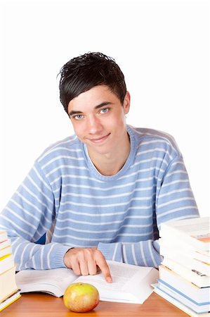 simsearch:400-04505681,k - Young student is sitting on desk with study books and learns for his exams. He smiles happy into camera. Isolated on white. Stock Photo - Budget Royalty-Free & Subscription, Code: 400-04176794