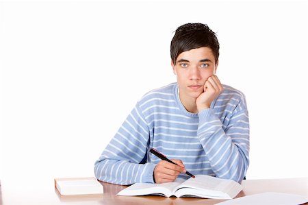 simsearch:400-04505681,k - Young student is sitting on desk with open book and learns for his exams. He looks neutral into camera. Isolated on white. Stock Photo - Budget Royalty-Free & Subscription, Code: 400-04179764