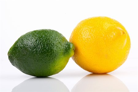 simsearch:400-06513460,k - Lime getting close to lemon on white background Stock Photo - Budget Royalty-Free & Subscription, Code: 400-04185371