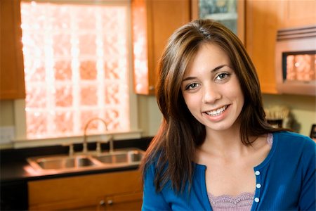 Pretty Caucasian young woman smiling in kitchen. Stock Photo - Budget Royalty-Free & Subscription, Code: 400-04186350