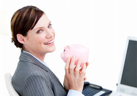 simsearch:400-04184165,k - Cheerful businesswoman holding a piggy-bank in the office Stock Photo - Budget Royalty-Free & Subscription, Code: 400-04186968