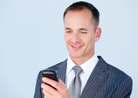 simsearch:400-05717420,k - Handsome businessman sending a text with his  phone in the office Stock Photo - Budget Royalty-Free & Subscription, Code: 400-04186991