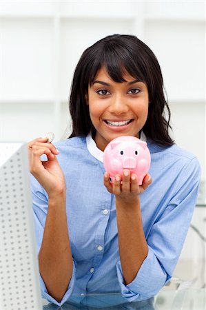 simsearch:400-04184165,k - Smiling businesswoman saving money in a piggybank in the office Stock Photo - Budget Royalty-Free & Subscription, Code: 400-04188096