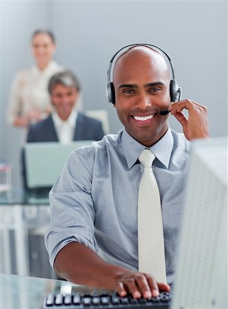 Ethnic businessman working at a computer with headset on in the office Stock Photo - Budget Royalty-Free & Subscription, Code: 400-04188559