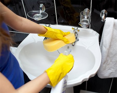 simsearch:400-04287497,k - Young woman cleaning a bathroom's sink with a sponge and detergent spray Stock Photo - Budget Royalty-Free & Subscription, Code: 400-04182664