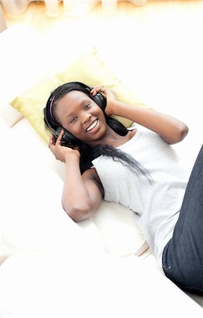 simsearch:400-04206778,k - Radiant woman listening music with headphones lying on a sofa in the living-room Foto de stock - Super Valor sin royalties y Suscripción, Código: 400-04182915