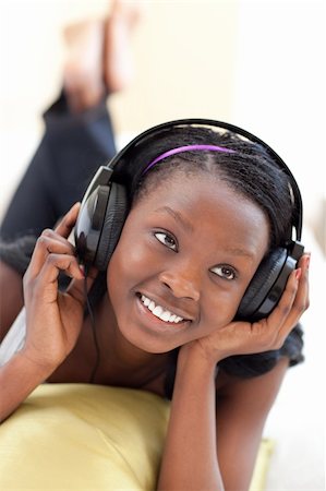 simsearch:400-05717451,k - Delighted woman listening music with headphones lying on a sofa in the living-room Stock Photo - Budget Royalty-Free & Subscription, Code: 400-04182954